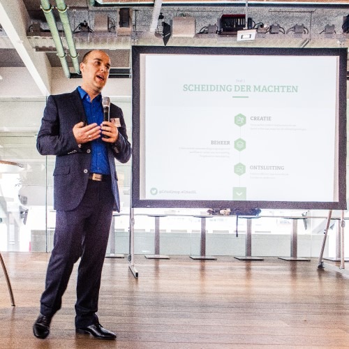 Man presenteert voor scherm met bedrijfsstrategieschema in moderne vergaderruimte.