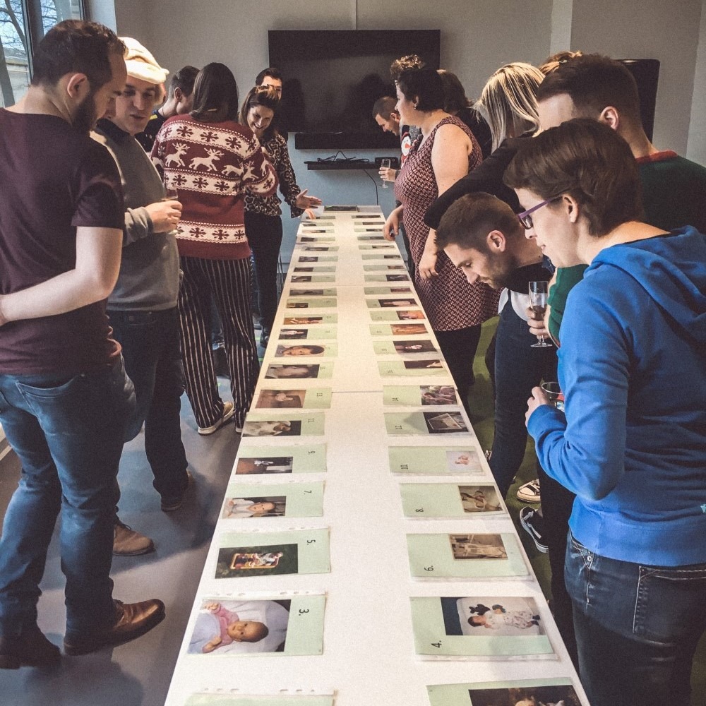 Groep mensen beoordeelt drukproeven op lange tafel bij een uitgeverij.