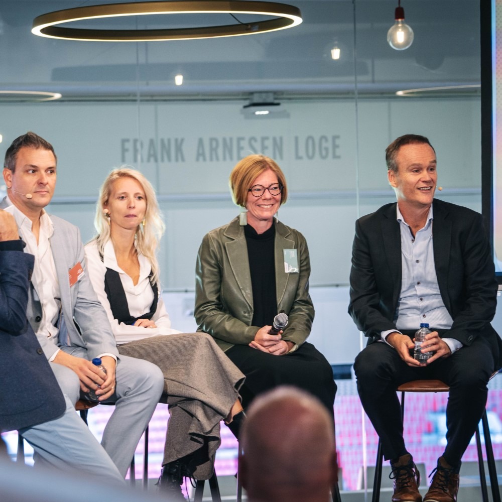 Panel discussion with five people on stage at an event about publishing software and editorial services.