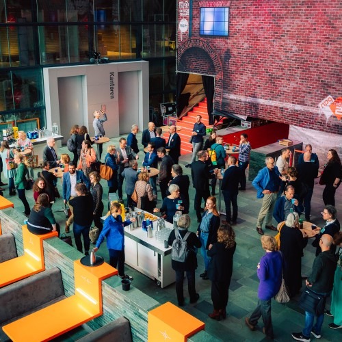 A group of people gathered in a modern reception area with colorful seating.